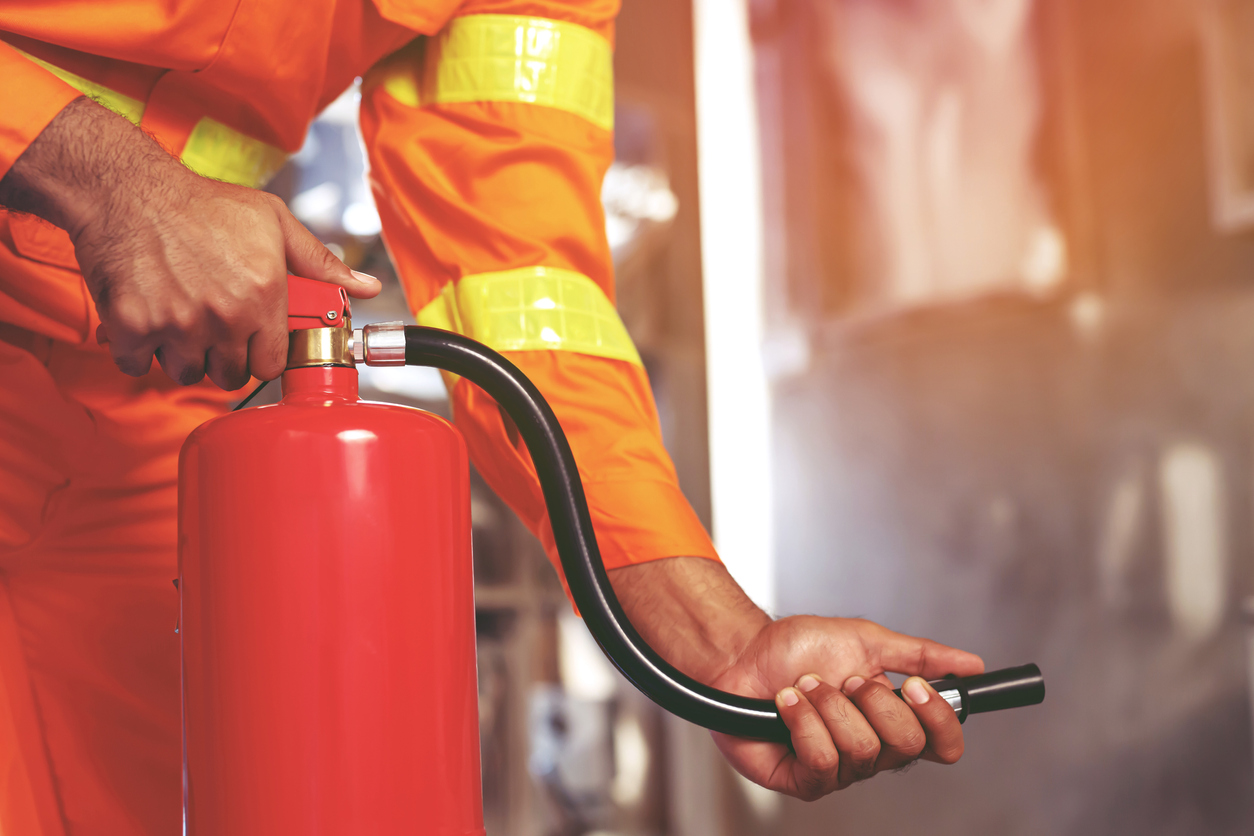 a hand pressing the fire extinguisher.