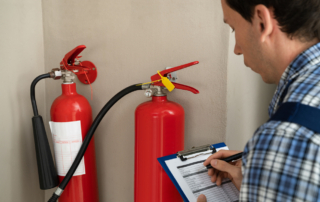 Male Professional Checking The Condition Of A Fire Extinguisher.