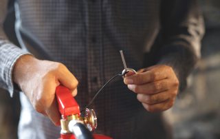 A man holding a fire extinguisher and removed the pin.