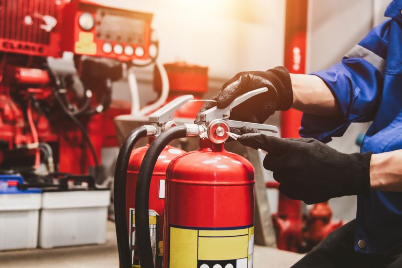 Engineer check fire extinguisher tank in the fire control room for safety.