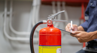 An expert doing Fire Extinguisher Inspection for High-Traffic Businesses