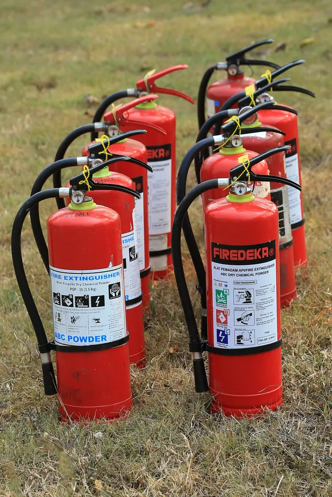 Different types of fire extinguishers on a grassy field.